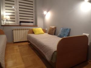 a bedroom with a bed with yellow and blue pillows at Apartament w Centrum in Krynica Zdrój