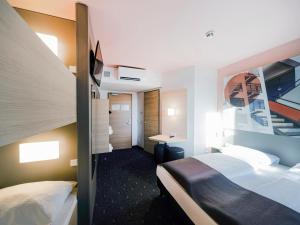 una camera d'albergo con 2 letti e una scrivania di B&B Hotel Dessau a Dessau