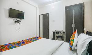 una camera con letto, TV e scrivania di FabHotel Lily Grand a Kakarmatha