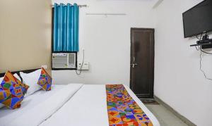 una camera con un letto e una televisione di FabHotel Lily Grand a Kakarmatha
