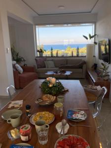 una mesa con platos de comida en la sala de estar en Villa Olymp, en Nea Potidaea