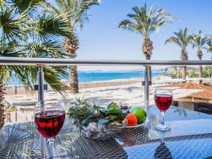 two glasses of wine on a table with a view of the beach at Sunset Beach Resort Aqua Lettings in Fethiye