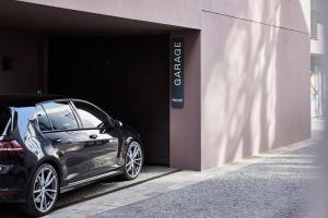 a black car parked next to a garage at Bettstadt Apartments in Vipiteno