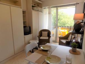 a living room with a table and chairs and a window at Saint Georges de Didonne - STUDIO TRES SYMPA - proche plage et centre - in Saint-Georges-de-Didonne