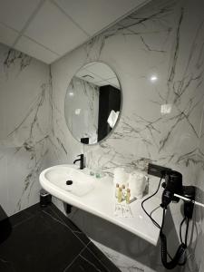 a bathroom with a white sink and a mirror at Hotel A Ladela in O Vicedo