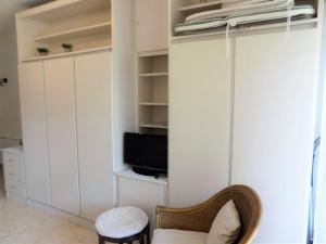 a living room with a tv and a chair at Saint Georges de Didonne - STUDIO TRES SYMPA - proche plage et centre - in Saint-Georges-de-Didonne +12 photos