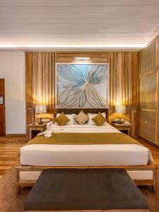 a bedroom with a large bed and a painting on the wall at Hotel Sigiriya in Sigiriya