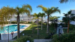 - Vistas a un complejo con palmeras y piscina en Penthouse Pure South Manilva Sea View en Castillo de Sabinillas
