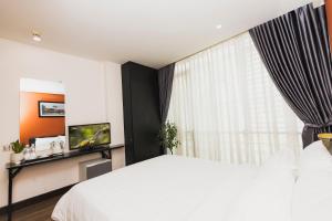 a bedroom with a white bed and a large window at The One Premium Hotel in Ho Chi Minh City +43 photos
