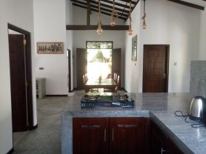 a kitchen with a stove and a counter top at Villa Conch by Om - Private House - Hikkaduwa in Hikkaduwa