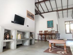 a living room with a table and a tv at Villa Conch by Om - Private House - Hikkaduwa in Hikkaduwa