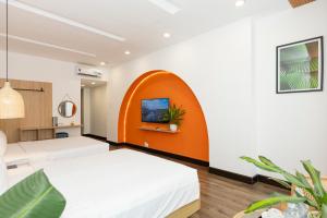 una camera con 2 letti e una parete arancione di The One Premium Hotel ad Ho Chi Minh