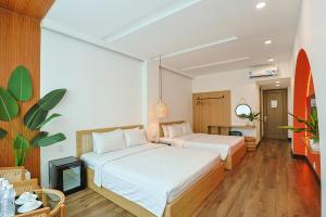 two beds in a hotel room with wooden floors at The One Premium Hotel in Ho Chi Minh City