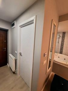 um corredor com uma porta branca e um espelho em Romantic Jacuzzi Luxury Apartment em Sinaia