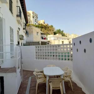 uma pequena mesa branca e cadeiras numa varanda em global 69 em Salobreña