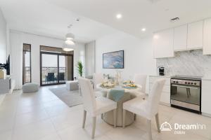 een keuken en een woonkamer met een tafel en stoelen bij Dream Inn Apartments - Rahaal - Burj al Arab View in Dubai