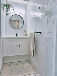 a white bathroom with a sink and a mirror at Shorebreak Nieuwpoort near the beach in Nieuwpoort-Bad