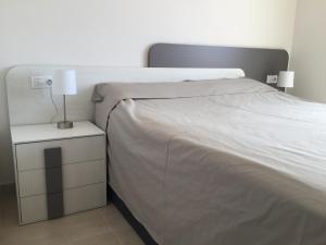 ein Schlafzimmer mit einem Bett und einem Nachttisch mit einer Lampe in der Unterkunft Vista Azul 3027 close to the beach, heated pool in winter in La Horadada