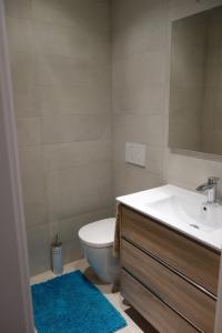 ein Badezimmer mit einem Waschbecken, einem WC und einem Spiegel in der Unterkunft Vista Azul 3027 close to the beach, heated pool in winter in La Horadada