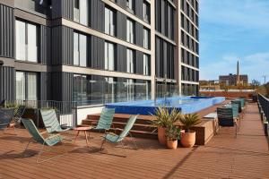 a deck with chairs and a swimming pool on a building at The Social Hub Barcelona Poblenou in Barcelona