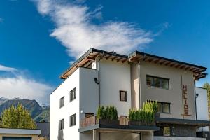 un edificio bianco con montagne sullo sfondo di Naturdorf Oberkühnreit a Neukirchen am Grossvenediger