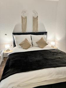 Schlafzimmer mit einem großen Bett mit einem schwarzen Kopfteil in der Unterkunft Charming Homes - Studio 20 in Wolfsburg