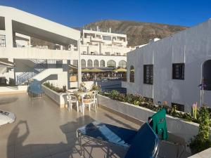 een balkon van een gebouw met tafels en stoelen bij Atlantic View Apartment Los Cristianos At Marysol Hotel Tenerife in Arona