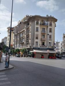 a man standing on a street corner in front of a building at Cosy Art Deco Apart in Casablanca