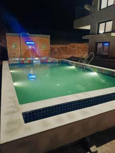 a swimming pool at night with a basketball hoop at VIDHI VILLA -Besides Valley View 360 with Luxurious Swimming pool & AC in Mahabaleshwar