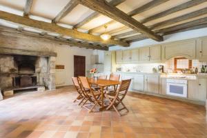 cocina grande con mesa de madera y sillas en Chateau de Mazelieres, en Espiens