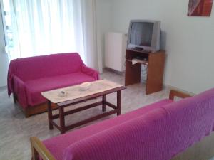 a living room with purple couches and a tv at Esperides Villas in Fourka
