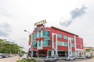 a red building with a sign on top of it at Capital O 90903 Blue Bell Hotel in Skudai