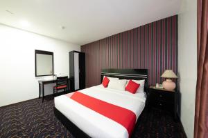 a hotel room with a large bed and a desk at Capital O 90903 Blue Bell Hotel in Skudai