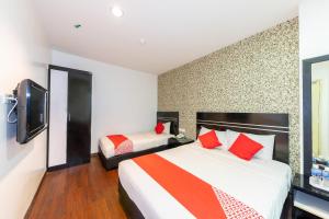 a hotel room with two beds and a tv at Capital O 90903 Blue Bell Hotel in Skudai
