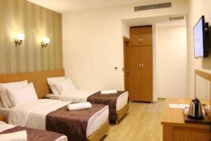 ein Hotelzimmer mit 2 Betten und einem TV in der Unterkunft Melidium Hotel in Beylikdüzü