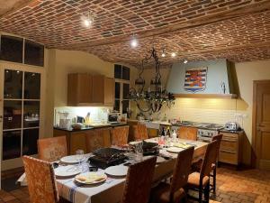una cucina con tavolo e sedie e una sala da pranzo di Les Confidences de Messire Sanglier, stylished guest houses a Beauraing