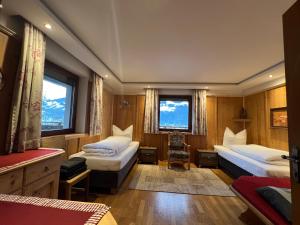 a bedroom with two beds and two windows at Landhaus Johannes in Hart im Zillertal