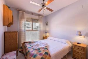 sypialnia z łóżkiem i wentylatorem sufitowym w obiekcie Apartamento Zeus 4 - PlusHolidays w mieście Calpe