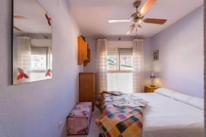 Schlafzimmer mit einem Bett und einem Deckenventilator in der Unterkunft Apartamento Zeus 4 - PlusHolidays in Calpe