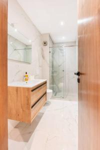 ein weißes Bad mit einem Waschbecken und einer Dusche in der Unterkunft TTHOLIDAYS Cosy Apartment Casablanca City Center in Casablanca