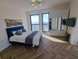 a bedroom with a large bed and large windows at JTower Royal Suites - The Penthouse - Alefimmoed in Jerusalem +87 photos