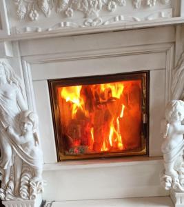 a white fireplace with a fire in it at Vilele Birta in Văliug