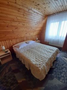 Vilele Birta في فاليوغ: غرفة نوم بسرير كبير في غرفة خشبية