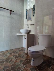 une salle de bain avec toilettes et lavabo dans l'établissement Alamku Bungalow, à Tirtagangga