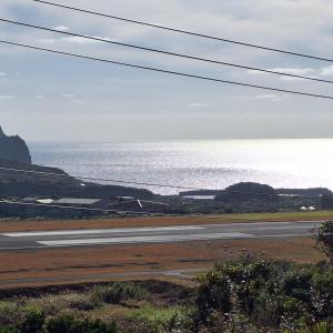 eine leere Straße mit dem Ozean im Hintergrund in der Unterkunft 八丈島メープルハウス in Hachijō