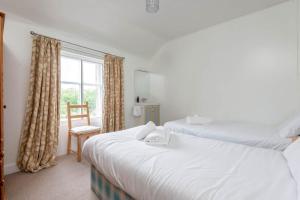 two beds in a room with a window at Park Place Elie, Perfect for the beach in Elie