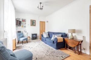 a living room with a blue couch and a table at Park Place Elie, Perfect for the beach in Elie