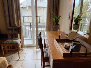 a room with a desk and a window with plants at El Greco Hotel in Heraklio