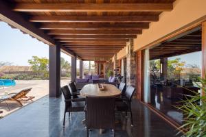 un patio al aire libre con mesa de madera y sillas en Villa Atlanntes con piscina en Fuerteventura, en Triquivijate