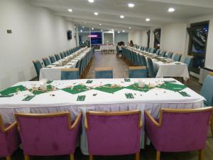 a row of tables and chairs with white tables and purple chairs at Melidium Hotel in Beylikduzu